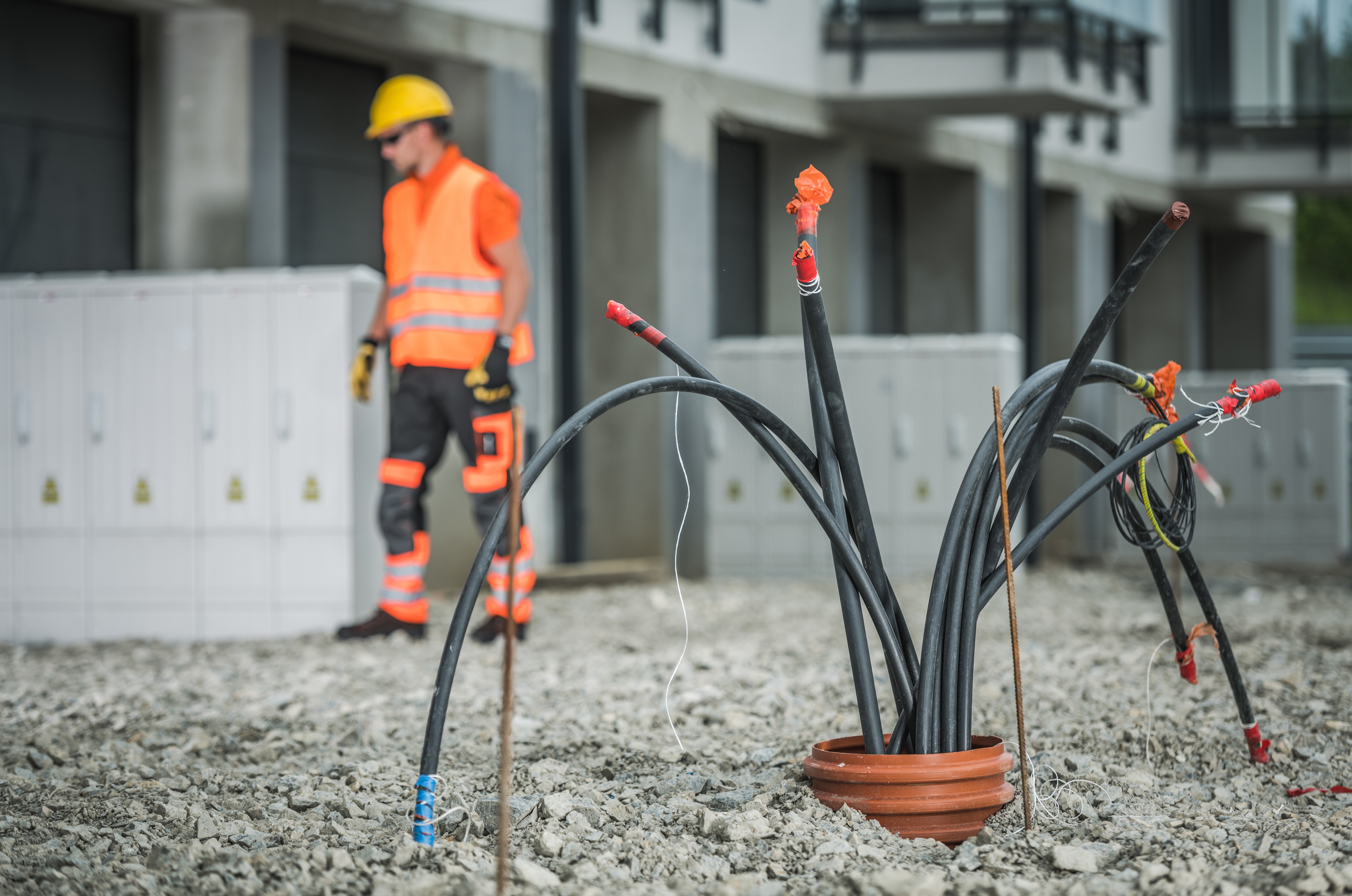 Utility construction worker inspecting underground cable installation at job site