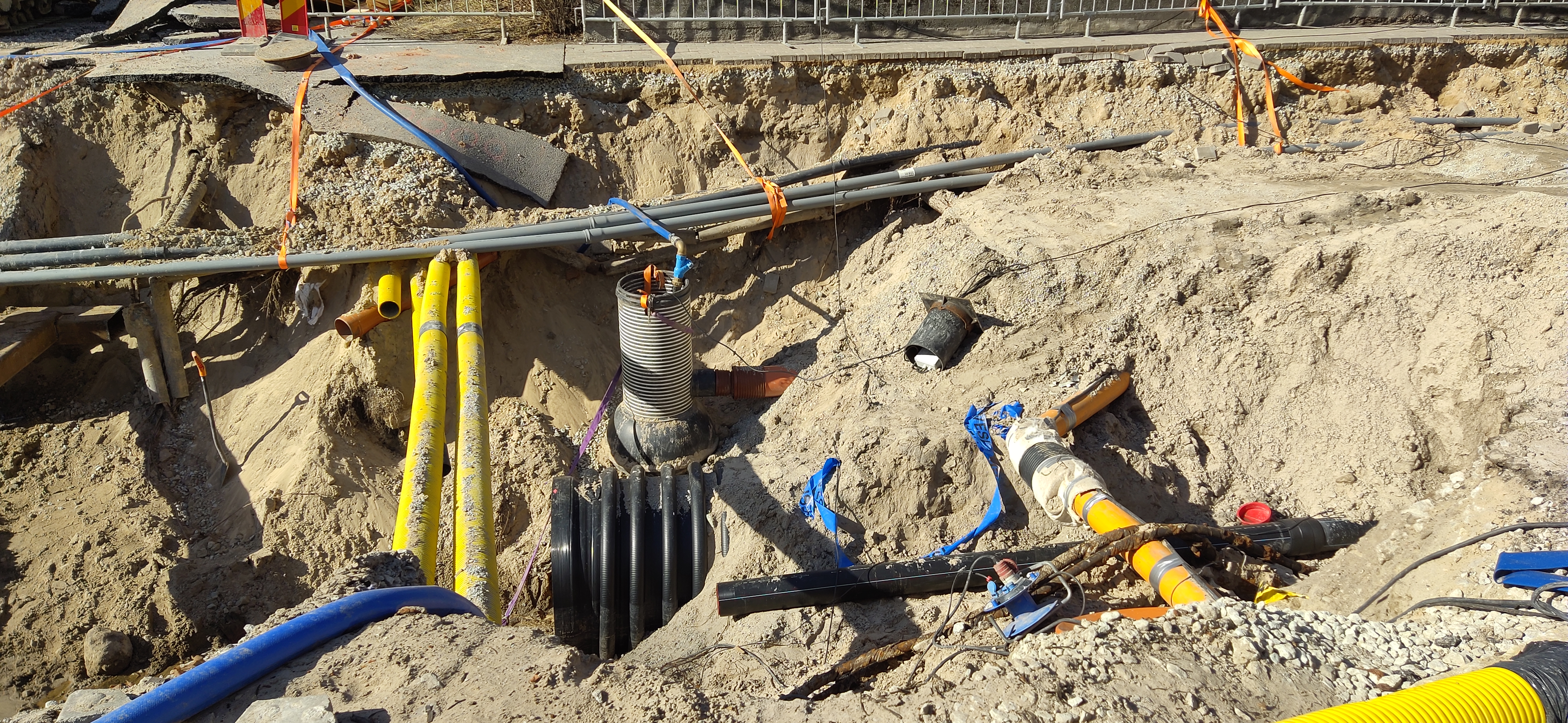 Multiple utility pipes laid in an open trench during underground utility trenching project